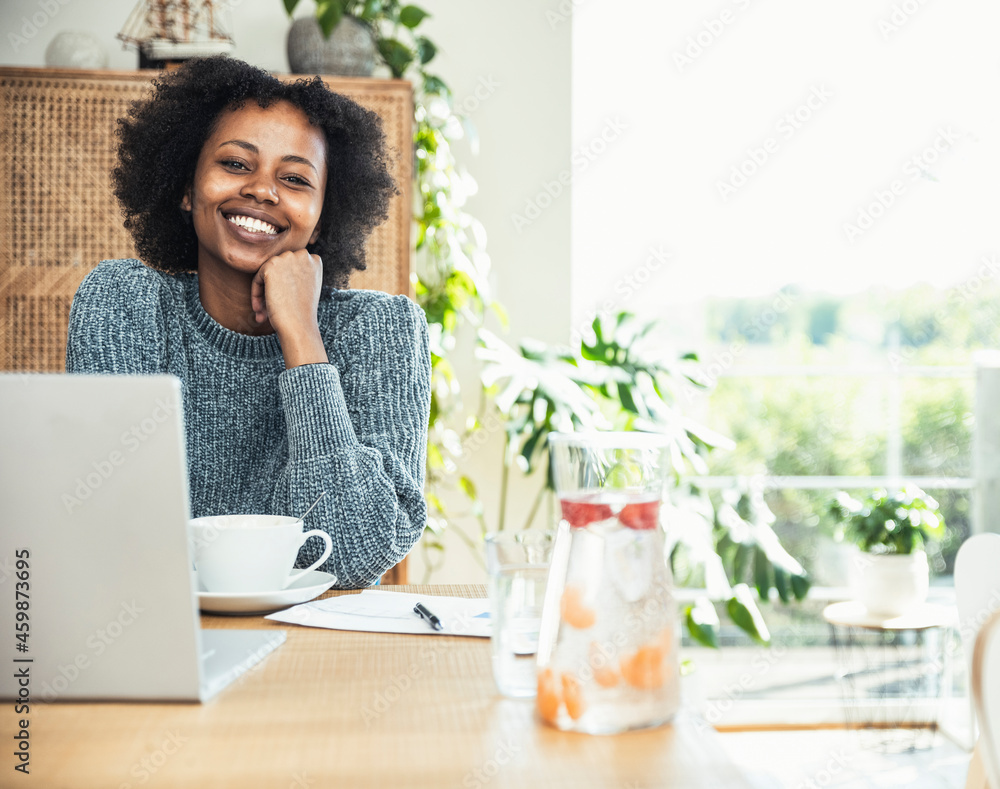 Young businesswoman with hand on chin smiling at desk Young businesswoman with hand on chin smiling at desk