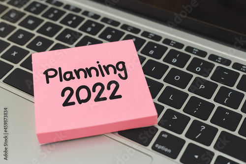 Sticky post notepaper with text planning 2022 on laptop keyboard.
