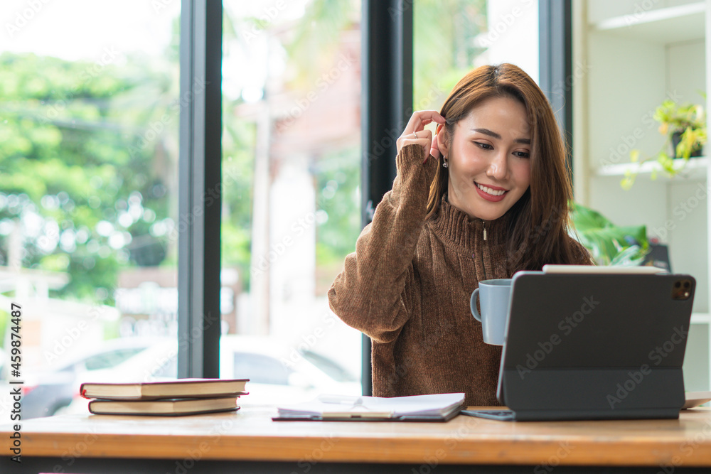 Beautiful cute asian young businesswoman in the cafe, using digital tablet and drinking coffee smiling Beautiful cute asian young businesswoman in the cafe, using digital tablet and drinking coffee smiling