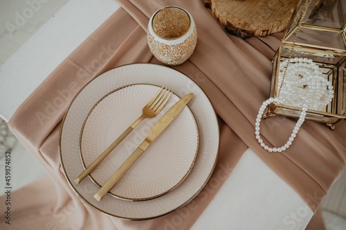 plate with utensils on a beige tablecloth