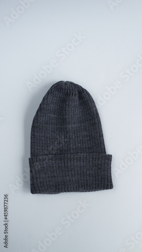 vertical photo on a white background red green pink and blue hats are knitted from wool yarn