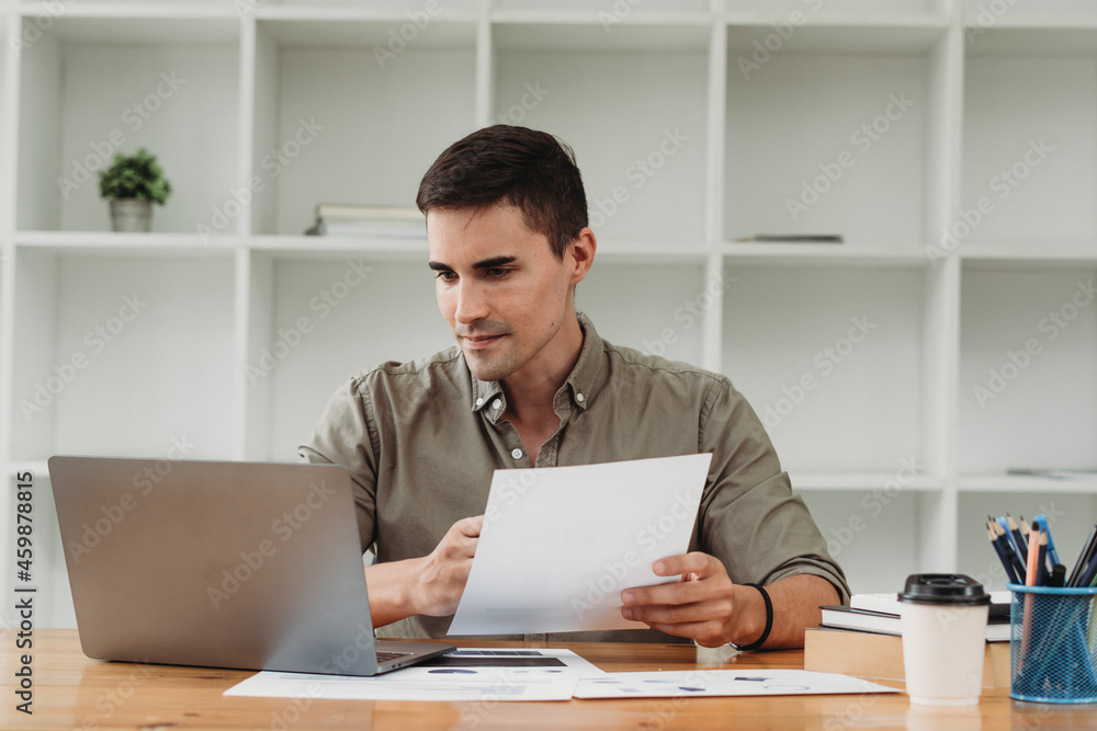 Businessman in shirt working on his laptop in an office. Open space office Businessman in shirt working on his laptop in an office. Open space office