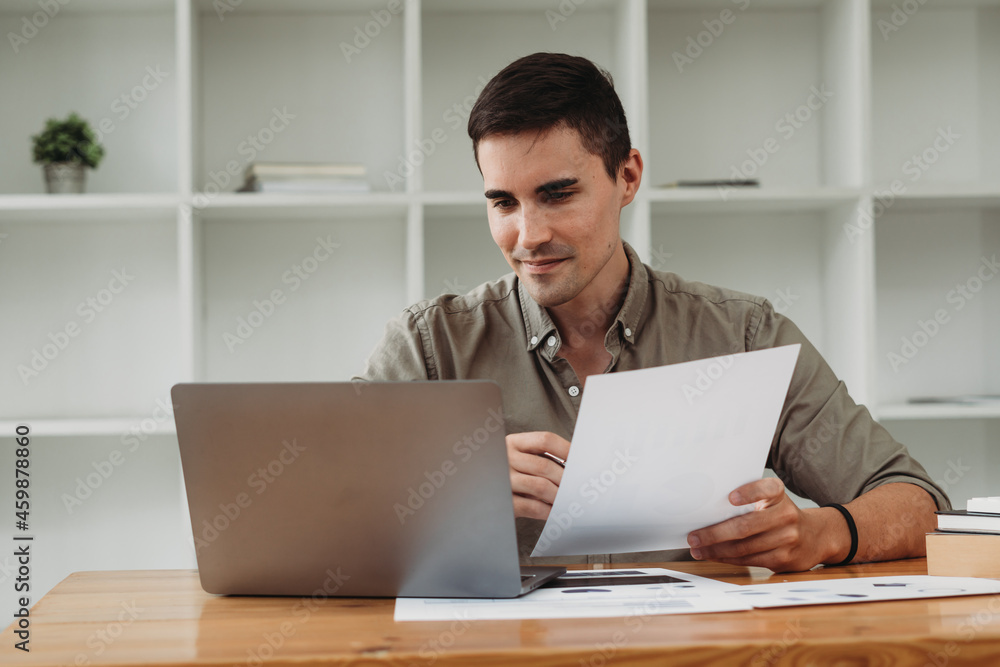 caucasian business man working with documents and laptop. caucasian business man working with documents and laptop.