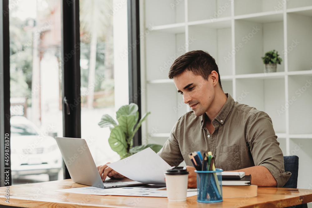 caucasian business man working with documents and laptop. caucasian business man working with documents and laptop.