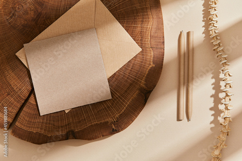 Flat lay of creative composition with mock up visit cards, wood, natural materials, pencils, dry plants and personal accessories. Neutral colors, top view, template. photo