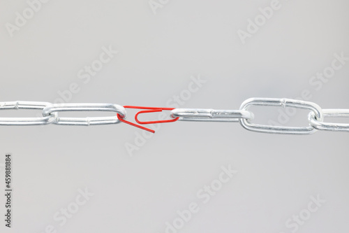 Konstfotografi Chrome chain in middle with red paper clip