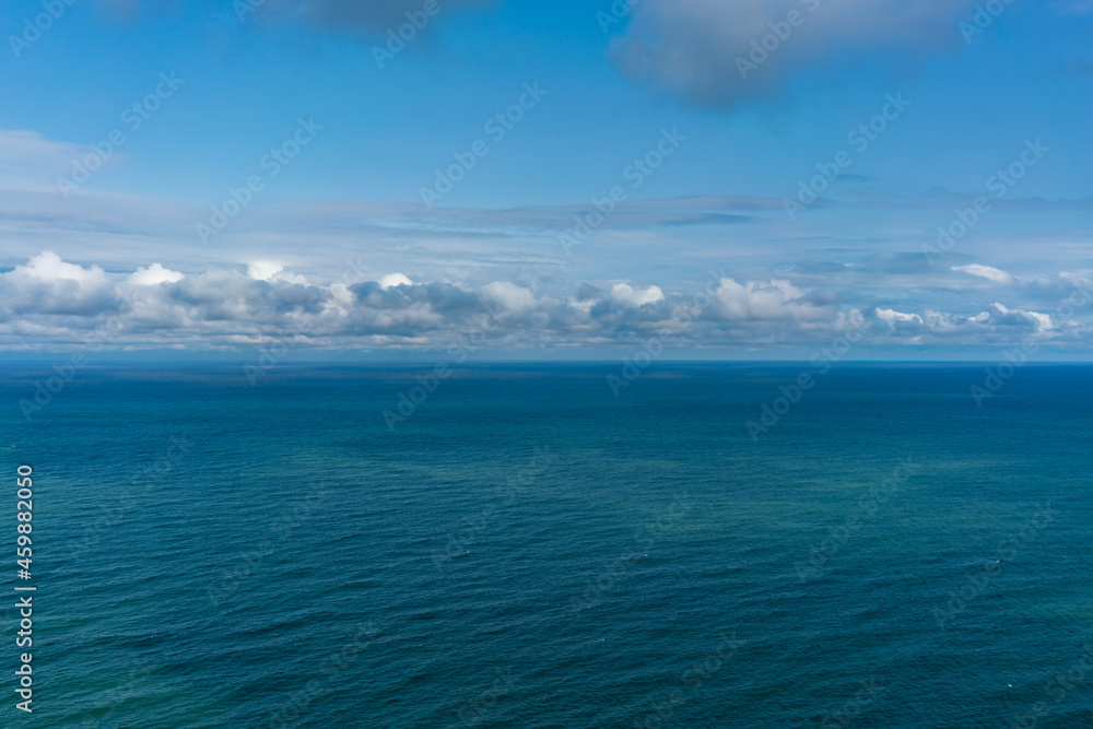 Top view of the sea on a sunny day under blue sky with white clouds
