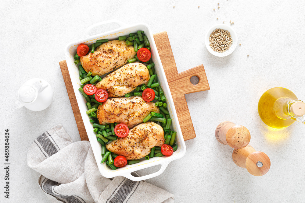Chicken meat, breast baked and green beans with tomatoes on white background. Keto diet. Healthy food. Top view. Chicken meat, breast baked and green beans with tomatoes on white background. Keto diet. Healthy food. Top view.
