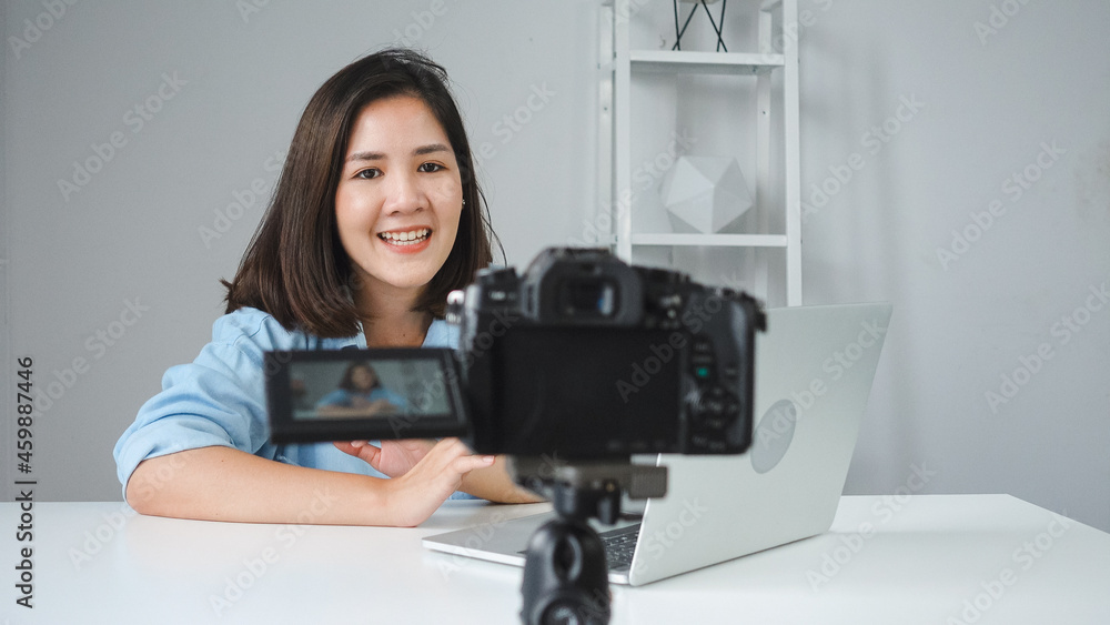 Happy beautiful Asian woman answer question from her subscribers. Female blogger recording video with laptop from camera to filming a question and answer video. Happy beautiful Asian woman answer question from her subscribers. Female blogger recording video with laptop from camera to filming a question and answer video.