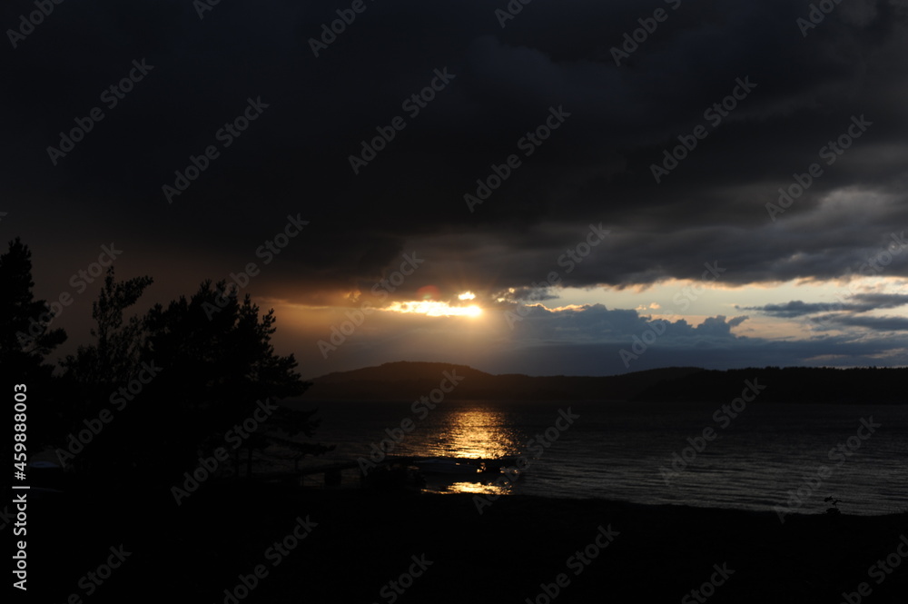 Sunset with wooden pier or deck on a calm day with sun reflecting in the sea