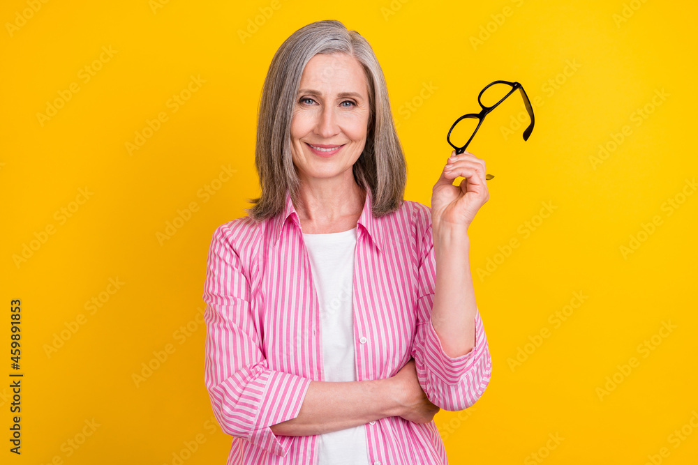 Portrait of attractive cheerful intelligent grey-haired woman granny posing isolated over bright yellow color background