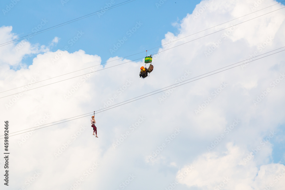 A girl crosses the river on a cable car in special equipment A girl crosses the river on a cable car in special equipment