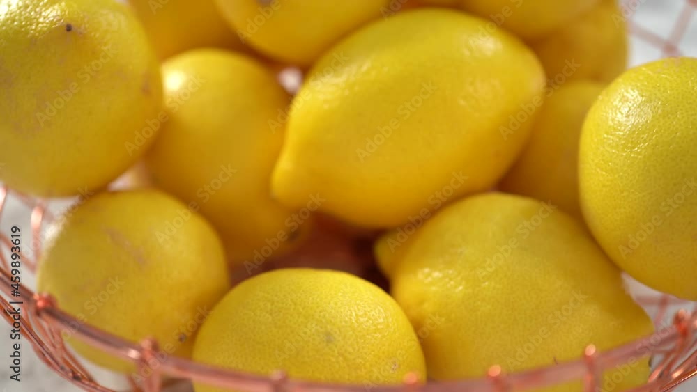 Step by step. Fresh organic lemons in a wire basket on a marble surface. Step by step. Fresh organic lemons in a wire basket on a marble surface.