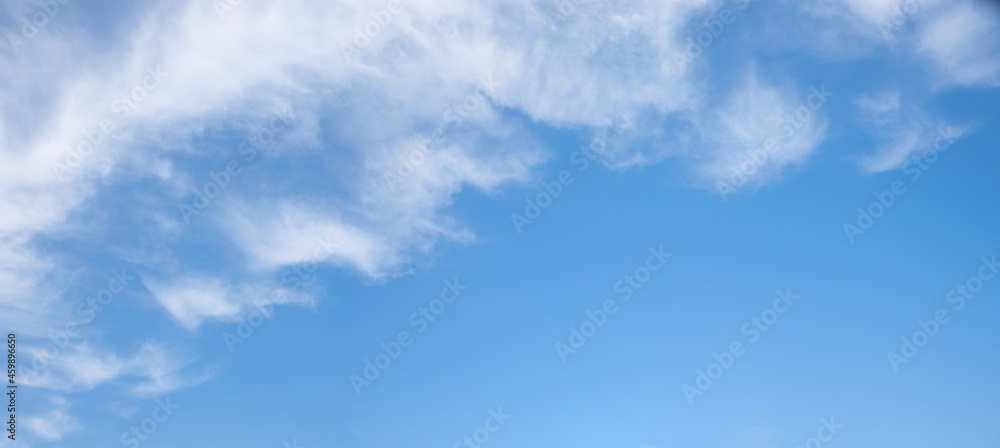 blue sky with fluffy clouds in the diagonally upper half