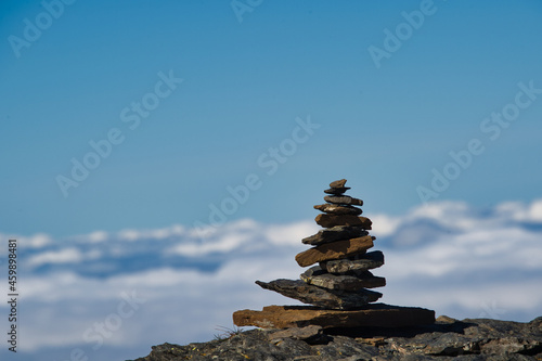 Stone men in the snowy swiss mountains with sea of fog and blue sky 