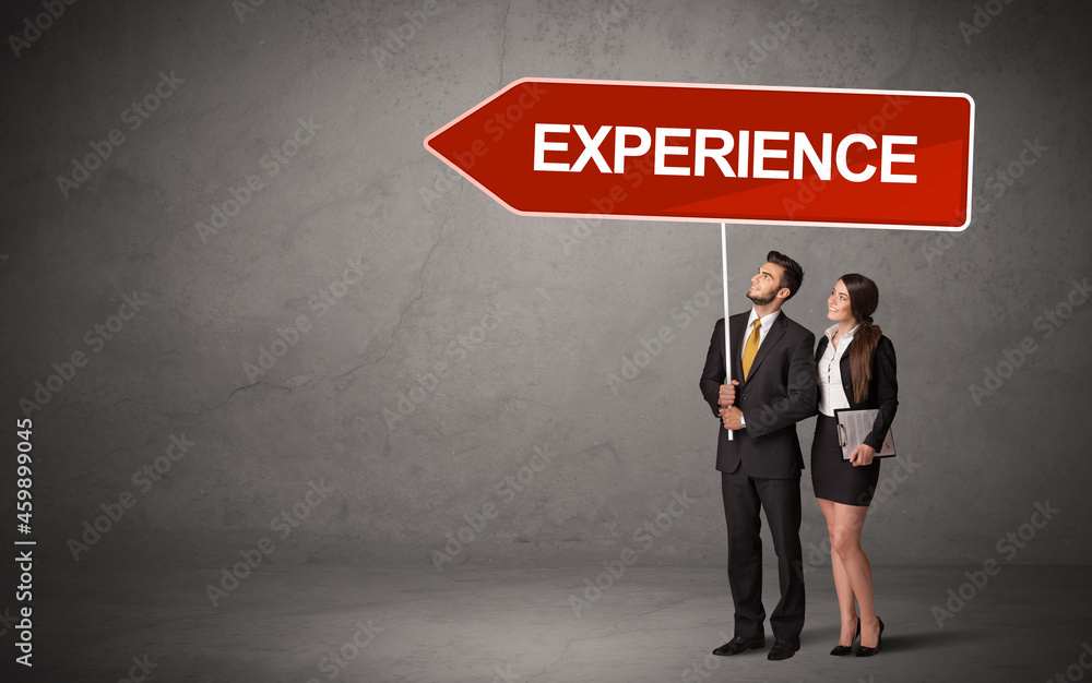 Fototapeta premium Young business person in casual holding road sign