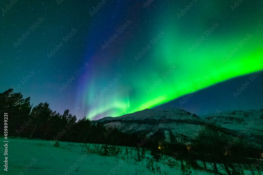 Nordlichter in Troms, Norwegen. Aurora Borealis spiegelt sich im Fjord und leuchtet über den schneebedeckten Bergen. the lady dance in the sky, northern light