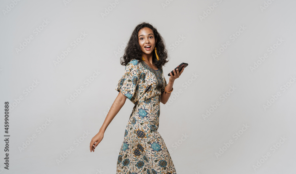 Young south asian woman wearing dress using mobile phone Young south asian woman wearing dress using mobile phone