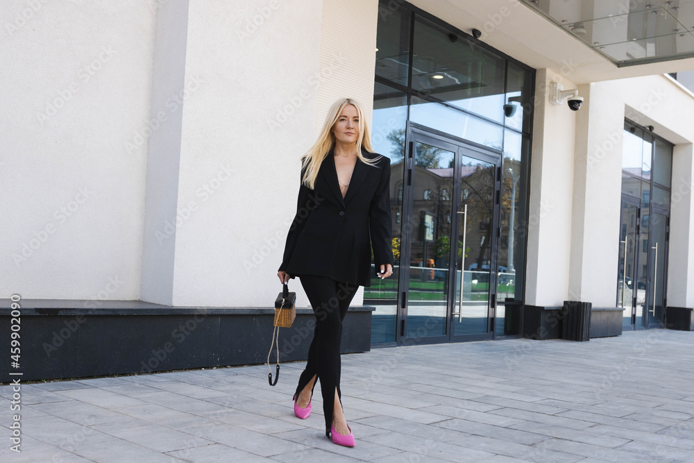 Fototapeta premium A business lady in a stylish suit poses on the street