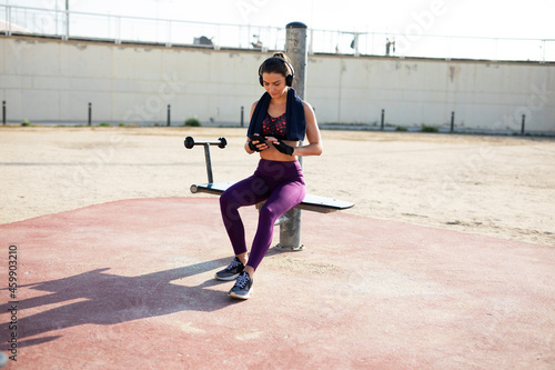Beautiful athlete woman listening the music. Young fit woman preparing for the training..