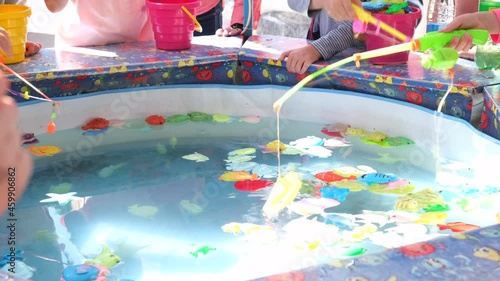 Minsk, Belarus - September 28, 2021: Children's catches plastic fish in an inflatable pool. Children's play with toy magnetic fishing rod 
