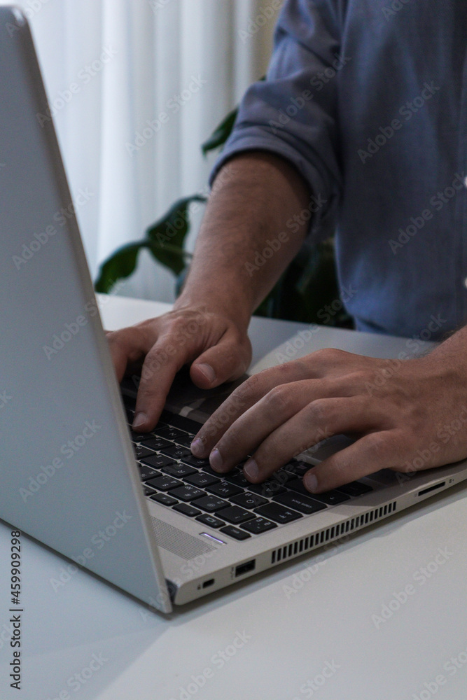 Close up of young man working on laptop. Work from home minimalism interior Close up of young man working on laptop. Work from home minimalism interior