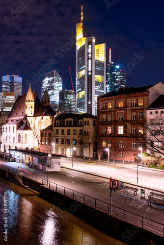 Night view from the Eisenerner Steg bridge to the illuminated cityscape of Frankfurt