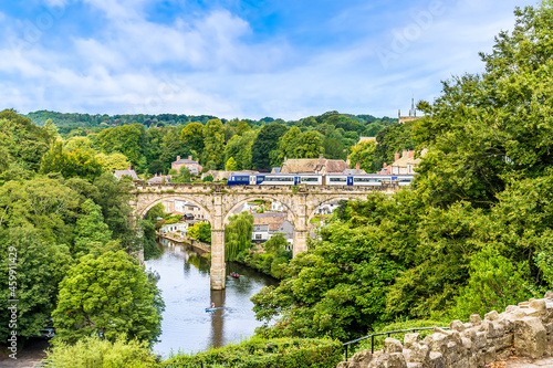 A view of a train crossing the viaduct in the town of Knaresborough in Yorkshire, UK in summertime