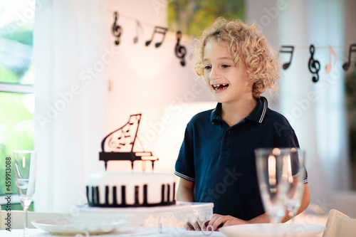Music and piano birthday party. Kid with cake.