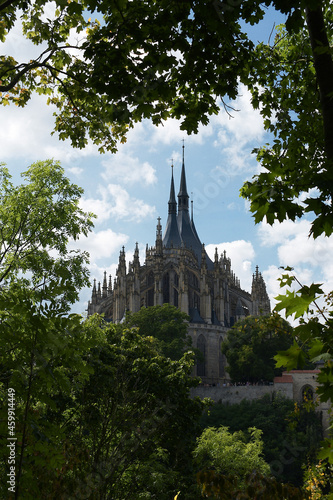 Church of St. Barbara Kutná Hora, trees in foreground, on a cloudy day