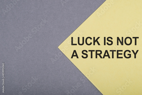 LUCK IS NOT A STATEGY - text on gray-yellow background.