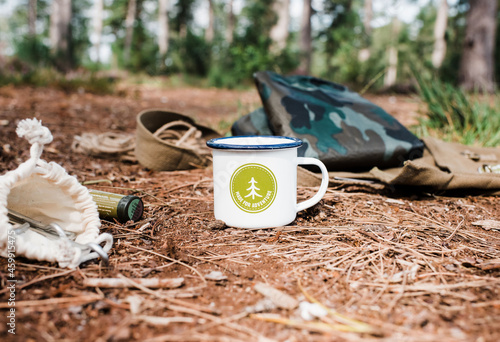 adventure kit and outdoor mug ready for camping in the forest photo