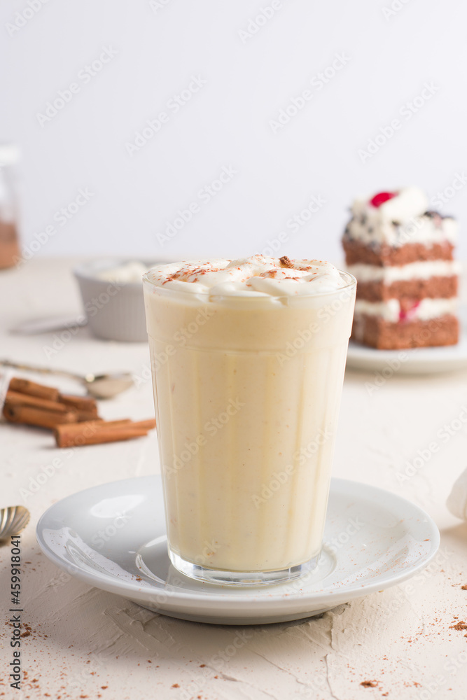 Eggnog cocktail against cake piece in cafe Eggnog cocktail against cake piece in cafe
