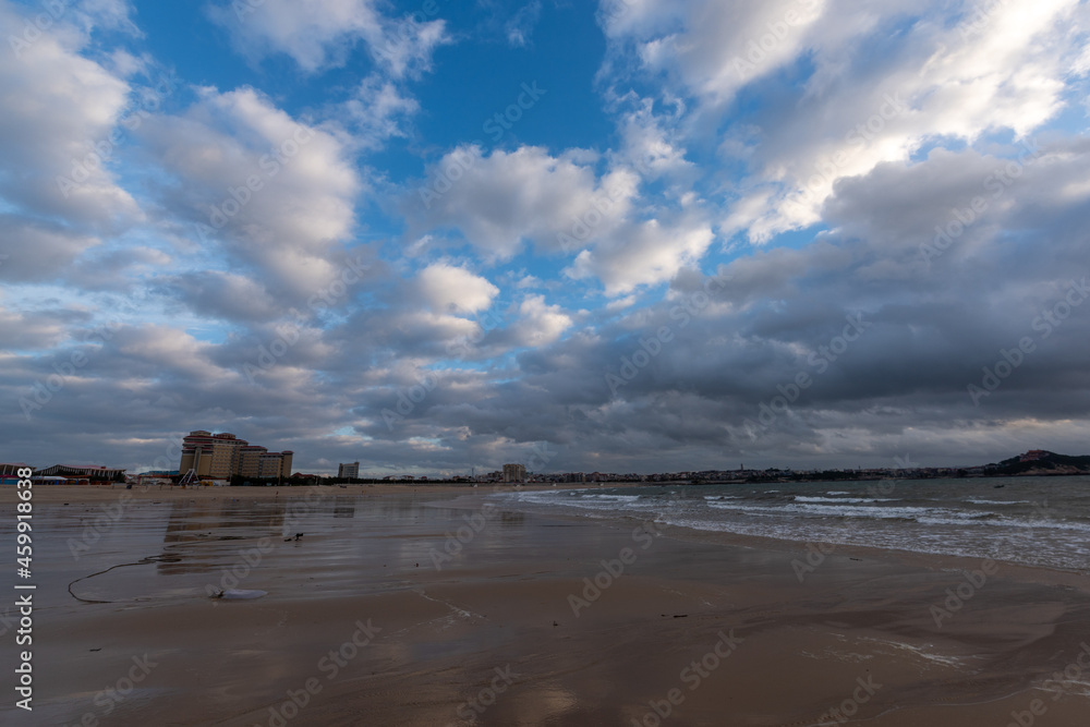 The sky is covered with dark clouds and the beach is cloudy