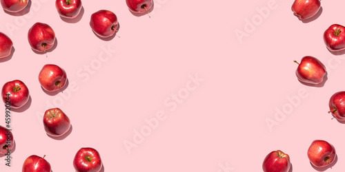 Red apples on pink background. Pattern, top view, flat lay, copy space.