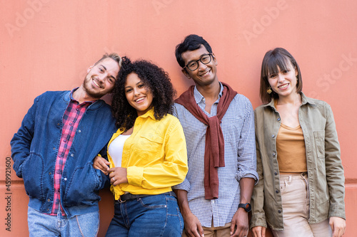 Multiracial friends group having fun at wall on university college campus - Diverse culture students portrait celebrating outside - Young smiling people looking at the camera for a group photo