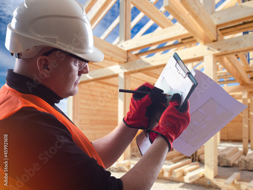 A builder next to wooden ho...