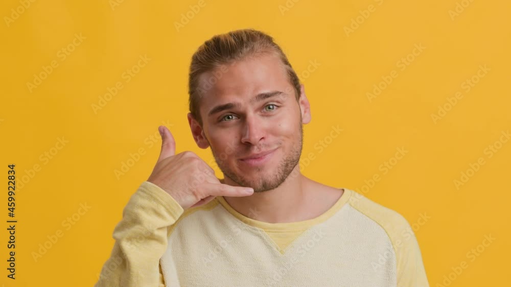 Call Me. Handsome Young Guy Showing Phone Gesture Isolated Over Yellow Background Call Me. Handsome Young Guy Showing Phone Gesture Isolated Over Yellow Background