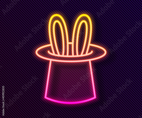 Glowing neon line Magician hat and rabbit ears icon isolated on black background. Magic trick. Mystery entertainment concept. Vector