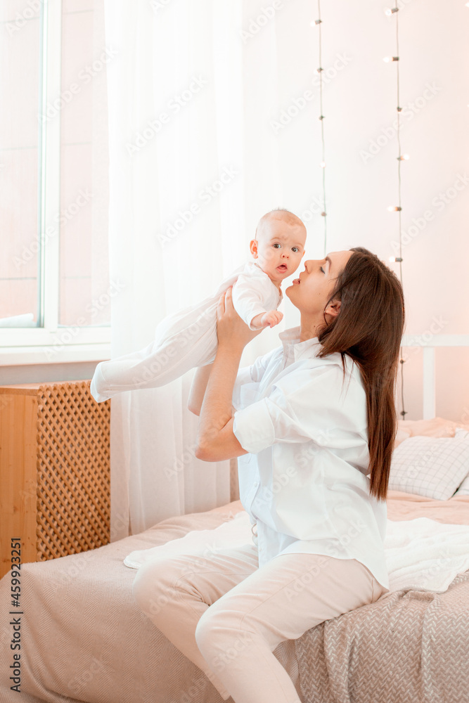 mom kisses the baby at home