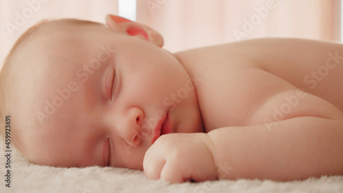 Healthy infant sleeping at home. Beautiful small baby sleeping. Close-up of infant sleeping. Macro shot of a small caucasian baby resting. Shot of napping child, afternoon nap.