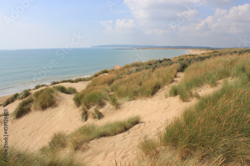 Camber sands East Sussex UK - view of Camber Sand dunes with sky and sea dunes held together with grasses stopping sand blowing away