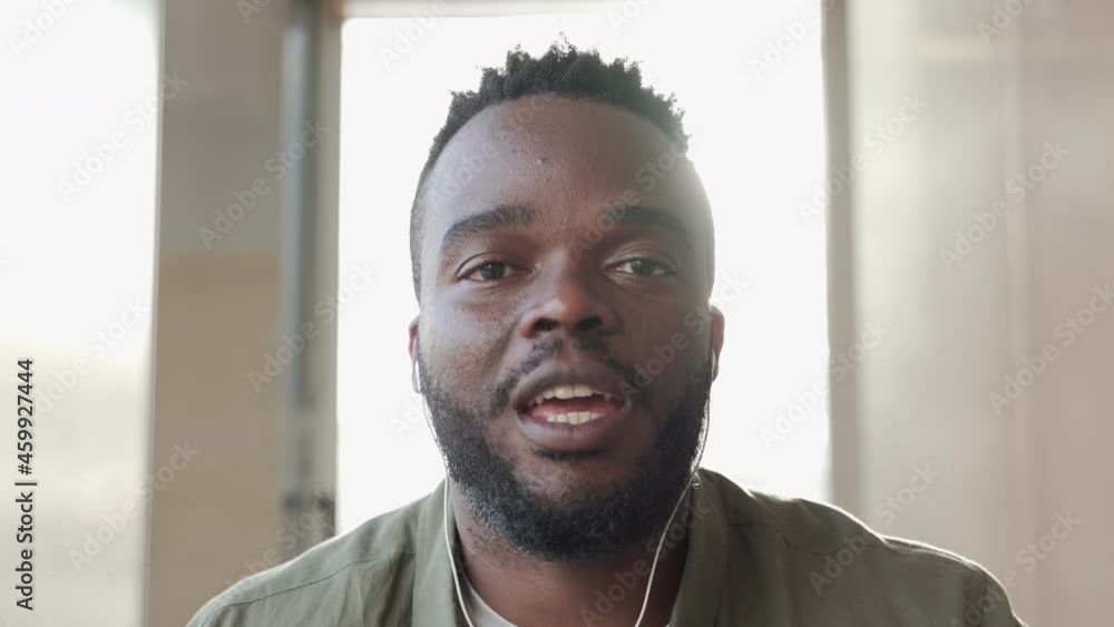 Close-up of a black man greeting and initiating a video call or online interview. Close-up of a black man greeting and initiating a video call or online interview.