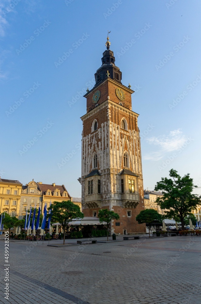 Krakow town hall tower, at sunrise with blue sky, with the square empty of people
