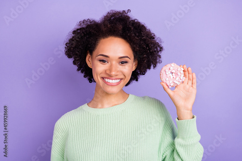 Photo of cheerful afro american positive woman hold hand donut smile enjoy isolated on purple color background