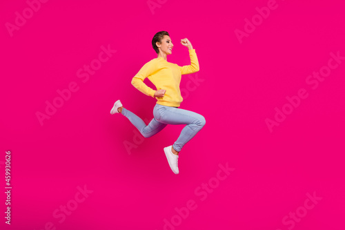 Photo of funny charming young woman dressed yellow pullover jumping running fast smiling isolated pink color background
