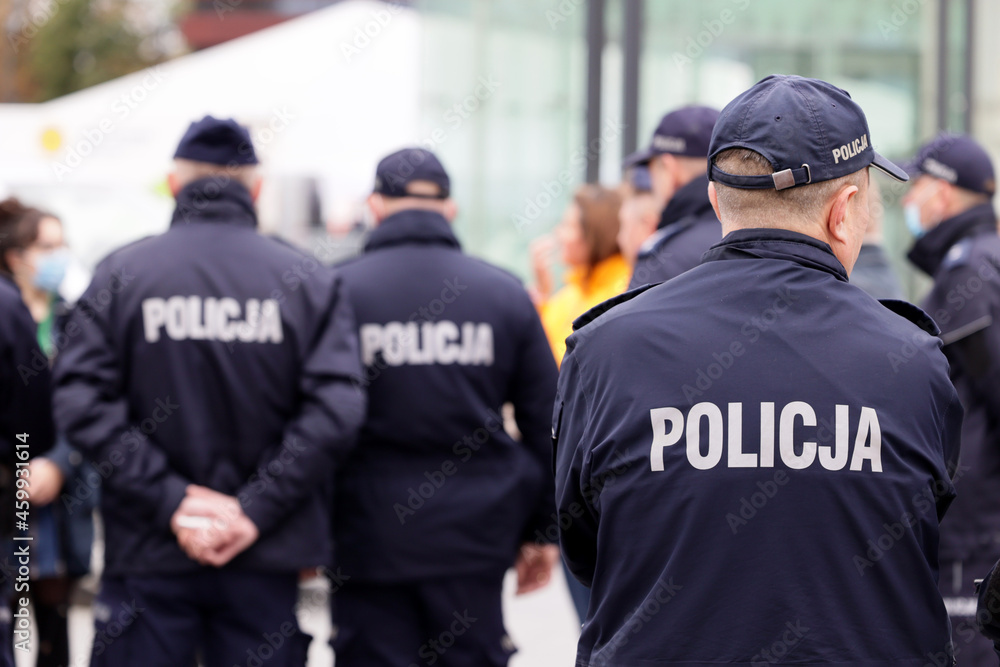 Polscy policjanci w niebieskim mundurze na zabezpieczeniu imprezy w mieście. - obrazy, fototapety, plakaty 