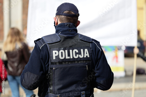 Polscy policjanci w niebieskim mundurze na zabezpieczeniu imprezy w mieście.