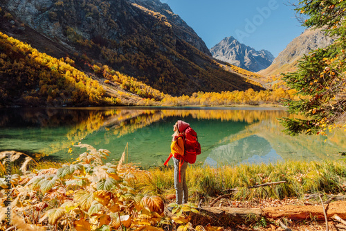 Φωτογραφία Hiker traveller woman and crystal lake in autumnal mountains.