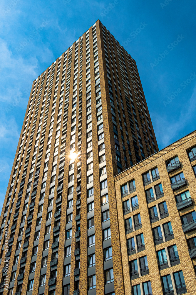 View of a multi-apartment residential complex of a new building against a background of blue sky.